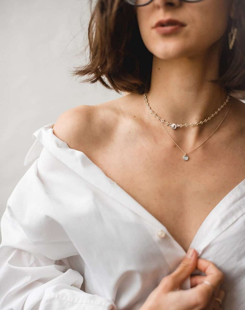 Fine necklace worn with an open white shirt