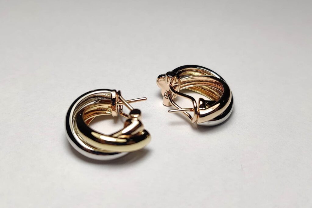 Silver and gold hoop earrings on a light surface