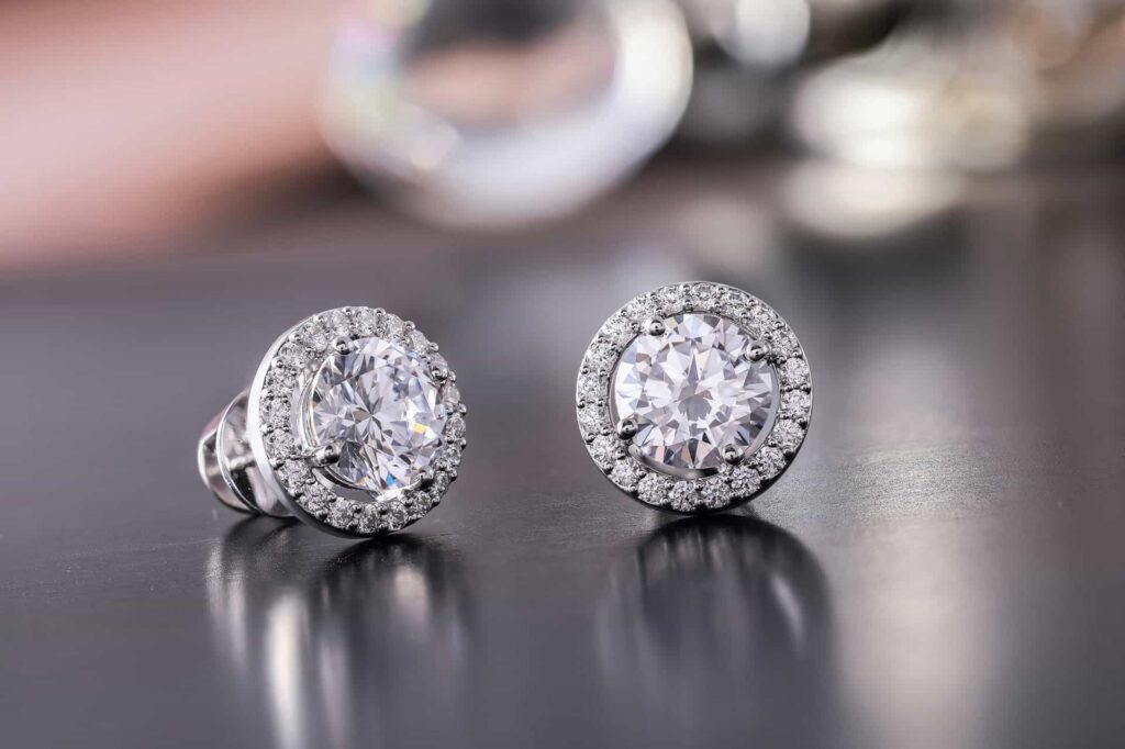 Pair of diamond stud earrings on a dark surface
