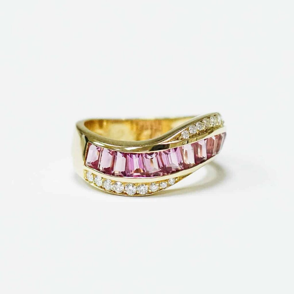 Gold ring set with a row of pink stones